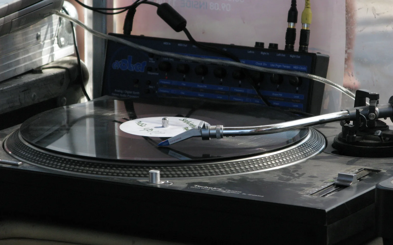 A vinyl turntable with tone arm and stylus, representing the equipment central to hip-hop music production