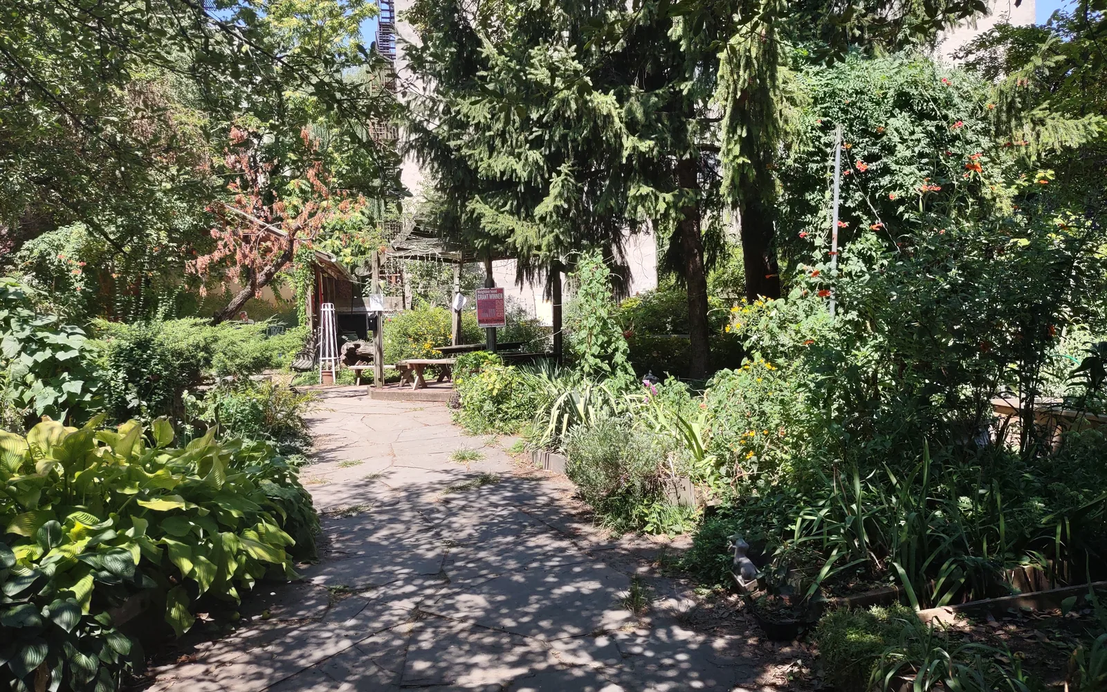 A community garden with raised beds and lush vegetation, representing neighborhood investment and collective growth